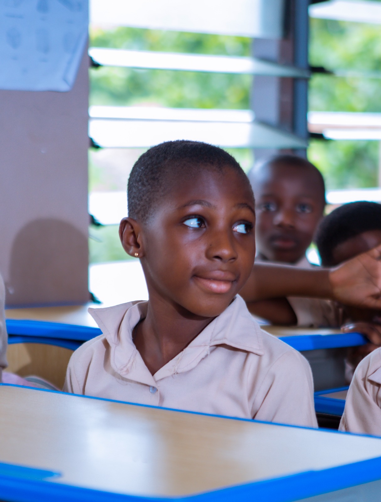 Student smiling thoughtfully in classroom setting